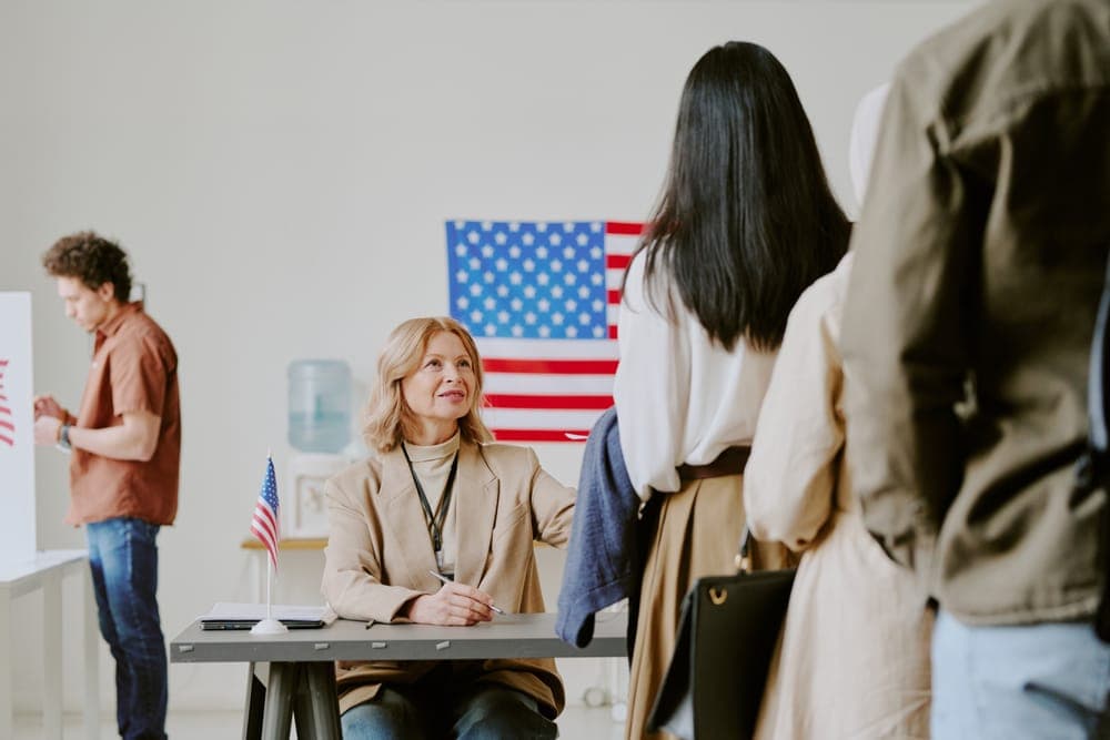 An EB-5 advisor meeting with a client in front of a US flag